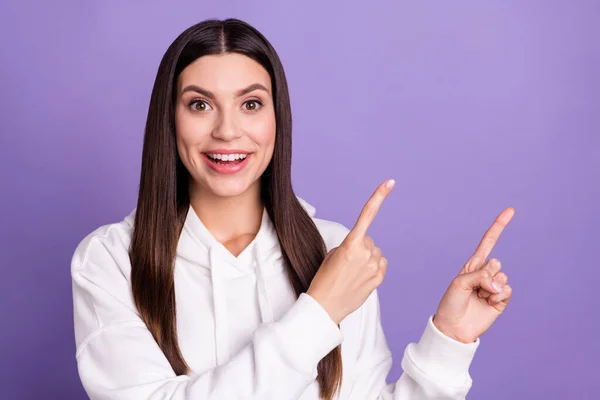 Foto van jonge vrolijke positieve verbaasd vrouw wijzen vinger lege ruimte geschokt nieuws geïsoleerd op violette kleur achtergrond — Stockfoto