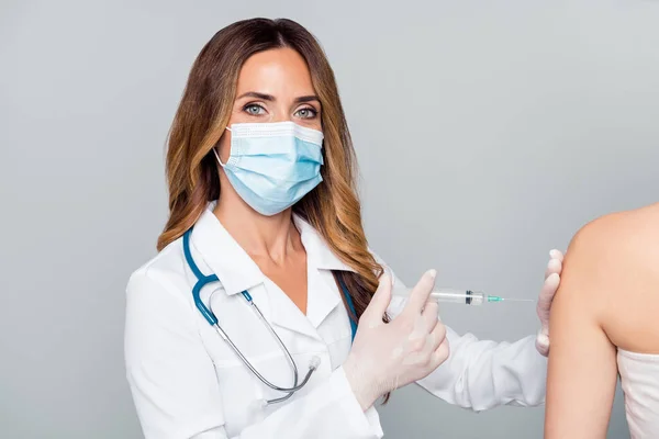 Photo of mature serious professional woman hold syringe make vaccine shot wear mask isolated on grey color background — Stock Photo, Image