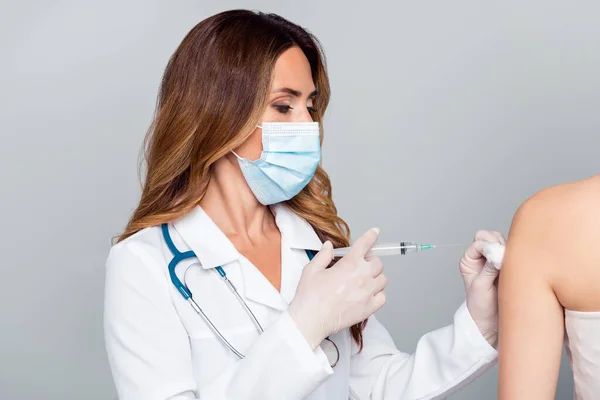 Photo of young serious professional woman hold needle make vaccine shot wear mask isolated on grey color background — Stock Photo, Image