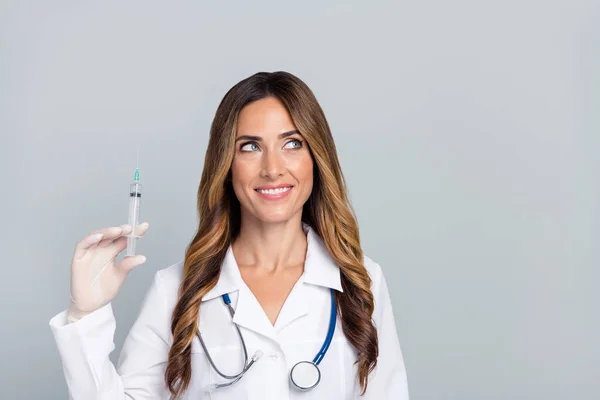 Retrato de atractiva mujer alegre doc sosteniendo jeringa copia espacio vacío aislado sobre fondo de color pastel gris — Foto de Stock