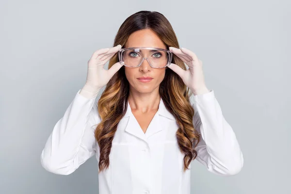 Retrato de atractiva mujer de pelo ondulado doc tocando las especificaciones de investigación de laboratorio aislado sobre fondo de color pastel gris — Foto de Stock