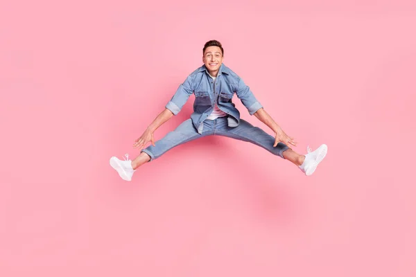Foto de tamaño completo de joven funky divertido descuidado sonriente saltando regocijo enérgico aislado sobre fondo de color rosa — Foto de Stock