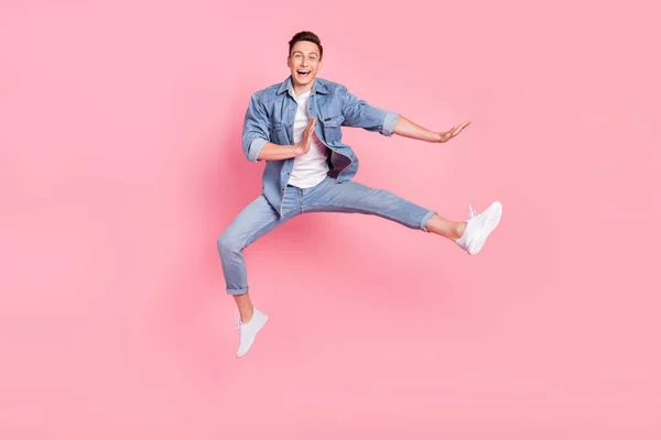 フルサイズ写真の若い笑顔良い気分正男ジャンプダンスで空気中に隔離されたピンク色の背景 — ストック写真