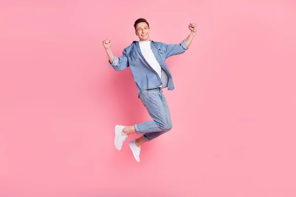 Pleine taille photo de jeune heureux heureux gars positif lever le poing dans la victoire saut triomphe isolé sur fond de couleur rose — Photo