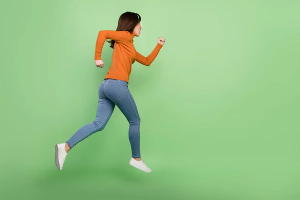 Teljes hossz testméret profil oldalnézetben szép sportos magabiztos lány ugrás futó elszigetelt felett élénk zöld színű háttér — Stock Fotó
