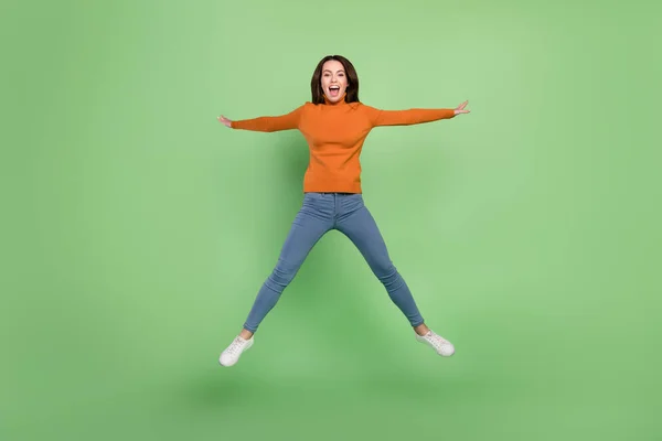 Vista completa del tamaño del cuerpo de la atractiva chica alegre extática saltando teniendo buen humor divertido aislado sobre fondo de color verde brillante — Foto de Stock