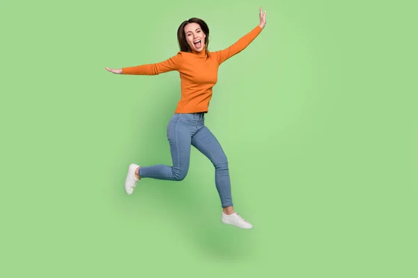 Pleine longueur corps taille vue de attrayant gai mince fille sautant avoir plaisir à marcher en cours d'exécution isolé sur fond de couleur verte — Photo