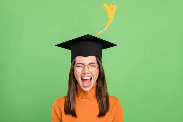 Portret van aantrekkelijke trendy vrolijke dromerige grappige meisje master degree met plezier borstel vliegen geïsoleerd over groene kleur achtergrond — Stockfoto