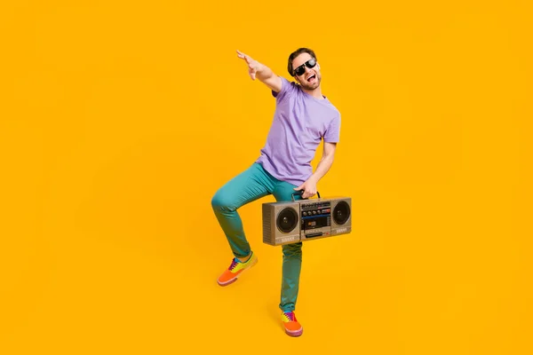 Φωτογραφία από αστείο funky τύπος κρατήσει boom box χορό απολαύσετε ντισκοτέκ φορούν βιολετί t-shirt απομονωμένο κίτρινο χρώμα φόντο — Φωτογραφία Αρχείου