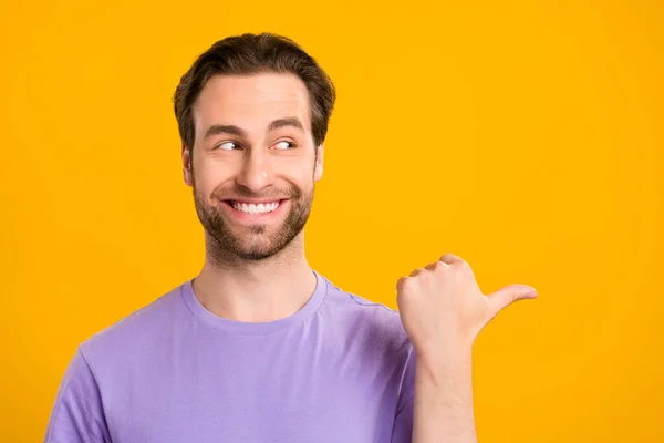 Foto de dulce encantador joven vestido púrpura camiseta mirando pulgar vacío espacio aislado color amarillo fondo — Foto de Stock