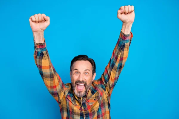 Foto de hooray brunet hairdo age man hands up wear yellow shirt isolated on blue color background —  Fotos de Stock