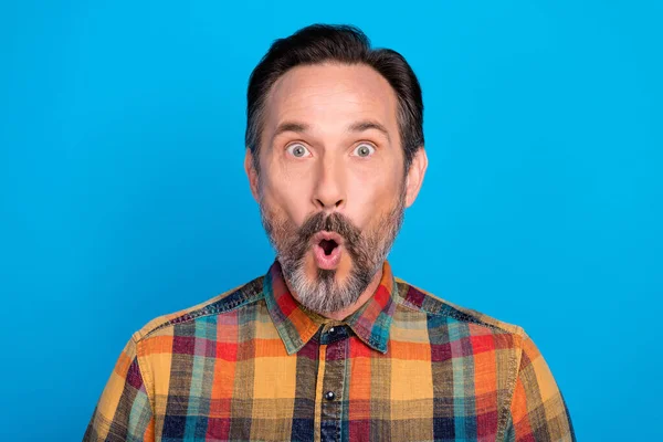 Zdjęcie portret człowiek patrząc zdumiony w kratę koszula odizolowane jasnoniebieski kolor tło — Zdjęcie stockowe