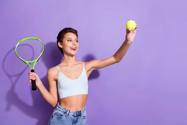 Foto portret meisje glimlachen houden racket spelen tennis met bal geïsoleerde pastel violette kleur achtergrond — Stockfoto