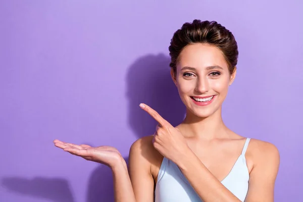 Foto retrato menina no topo azul mostrando espaço em branco dedo na palma isolado pastel cor violeta fundo — Fotografia de Stock