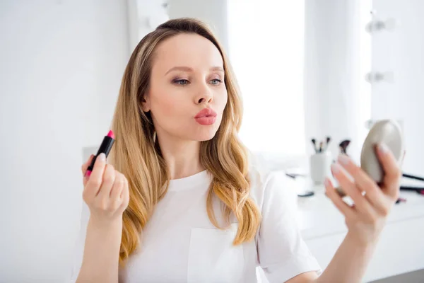 Foto portræt ung kvinde i hvidt outfit gør fyldes op anvende læbestift på udskårne læber - Stock-foto