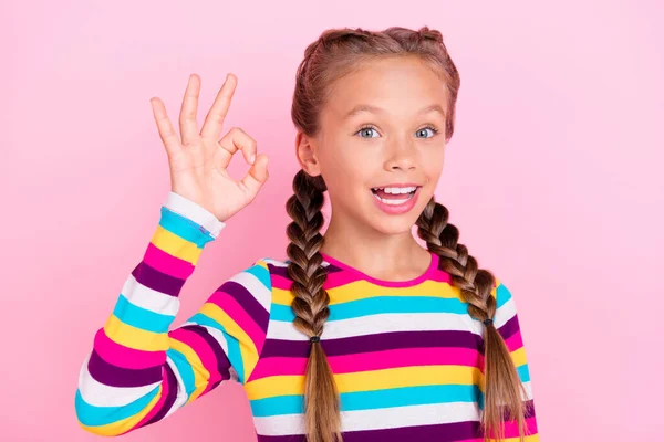 Фото веселых положительных маленьких леди пальцы показывают хорошо знак носить полосатую рубашку изолированный розовый цвет фона — стоковое фото