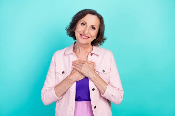 Foto ritratto donna in abiti casual sorridente grato tenere le mani sul petto isolato vibrante colore verde acqua sfondo — Foto Stock