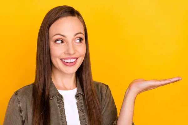 Kuva unenomainen onnellinen kypsä nainen pidä käsi tyhjä tila näyttää valitse eristetty keltainen väri tausta — kuvapankkivalokuva