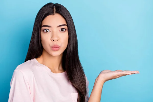 Foto de la muchacha joven pucheros labios demuestran producto oferta de promoción sugieren aislado sobre fondo de color azul —  Fotos de Stock