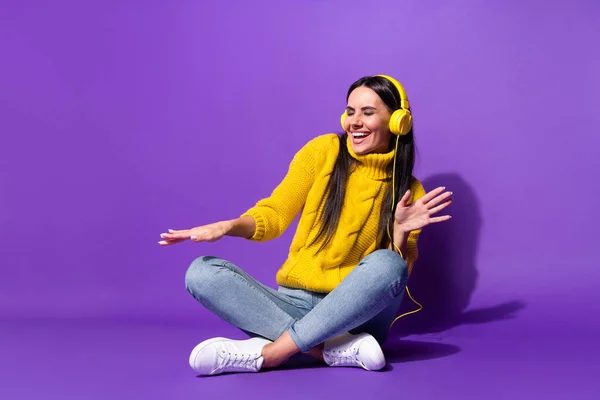 Foto in voller Länge von positiven unbeschwerte junge Mädchen sitzen toothy Lächeln Chilling isoliert auf violettem Hintergrund — Stockfoto