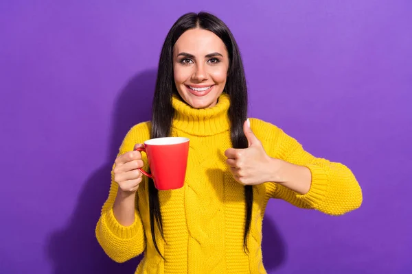 Retrato de charmoso alegre braço pessoa segurar café mostrar polegar até o sorriso dos dentes isolado no fundo cor roxa — Fotografia de Stock