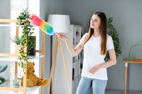 Портрет привабливої дбайливої веселої дівчини, що витирає пил, чистить квартиру вдома світла вітальня в приміщенні — стокове фото