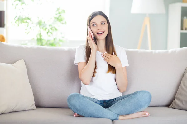 Portret van aantrekkelijk meisjesachtig vrolijk meisje zitten op divan praten over de telefoon rusten vrije tijd thuis binnen — Stockfoto