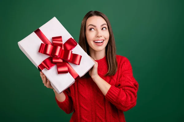 Foto de la joven excitada feliz sonrisa positiva curiosa sacudida presente caja de Navidad aislado sobre fondo de color verde —  Fotos de Stock