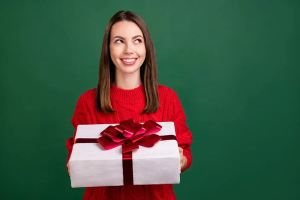 Photo de jeune fille heureux sourire positif rêve regarder vide espace tenir boîte cadeau anniversaire isolé sur fond de couleur verte — Photo