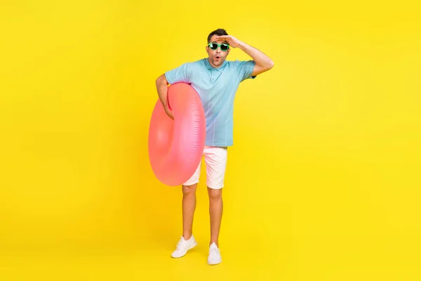 Lunghezza completa foto di impressionato uomo bruno con cerchio indossare t-shirt occhiali pantaloncini isolati su sfondo di colore giallo — Foto Stock