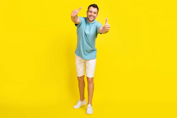 Фото фанк привабливого молодого хлопця, одягненого в синю футболку, посміхається, показуючи великі пальці вгору ізольований жовтий колір фону — стокове фото