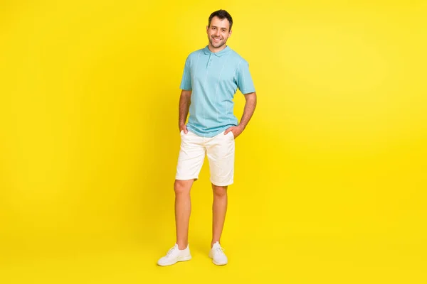 Ganzkörperfoto von guten brünetten Mann stehen tragen blaue T-Shirt Shorts isoliert auf gelbem Hintergrund — Stockfoto