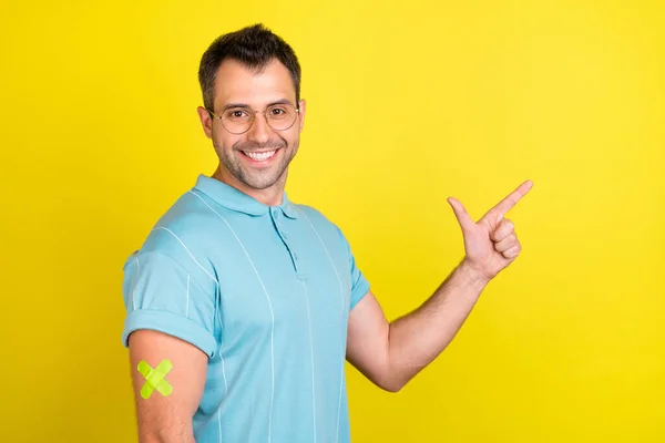 밝은 브루 넷 남자 포인트빈 공간의 사진에는 노란색 배경에 분리 된 청색 티셔츠를 착용하고 — 스톡 사진