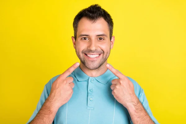 Bild av optimistisk brunett man punkt leende bära blå t-shirt isolerad på gul färg bakgrund — Stockfoto