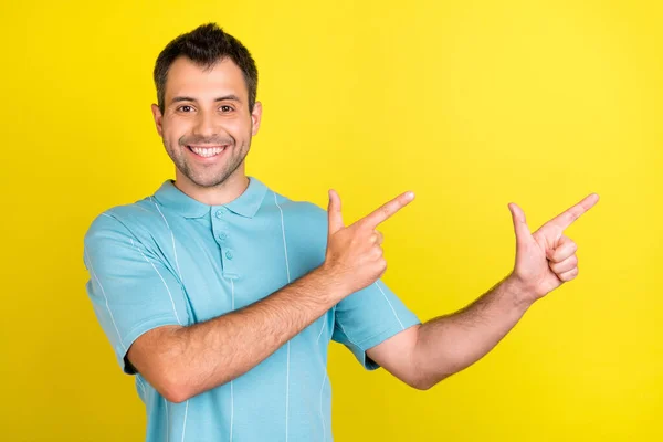 Foto di divertente affascinante giovane uomo indossare blu t-shirt puntando il dito vuoto spazio sorridente isolato colore giallo sfondo — Foto Stock