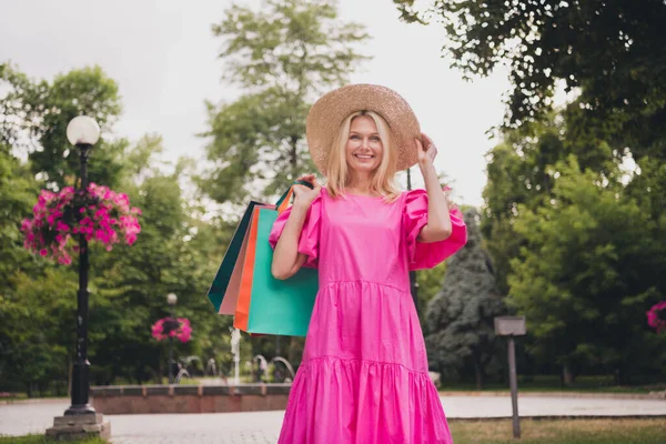 Zdjęcie słodkiej uroczej emerytki nosić różowy strój ręka ramię nakrycia głowy uśmiechnięty gospodarstwa okazje spaceru poza ulicą miejską — Zdjęcie stockowe