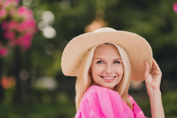 Foto de la señora pensionista adorable brillante vestida ropa rosa brazo mano diadema caminar sonriendo al aire libre fuera de la calle de la ciudad — Foto de Stock