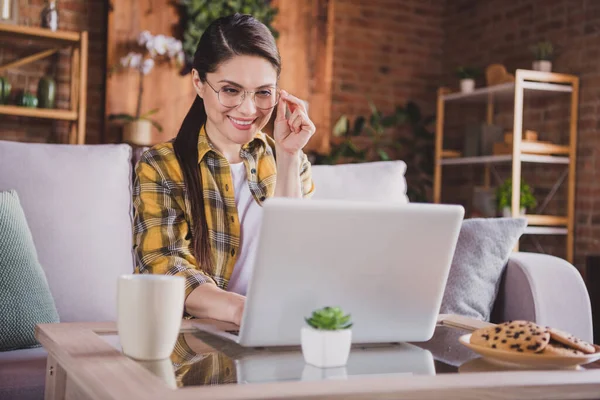 Foto wanita muda yang bahagia menarik mengenakan kacamata menggunakan laptop bersandar jauh di dalam rumah rumah — Stok Foto