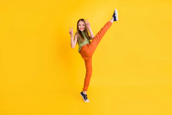 Полное фото тела смешной блондинка маленькая девочка сделать спорт V-знак носить блузки брюки изолированы на желтом фоне цвета — стоковое фото