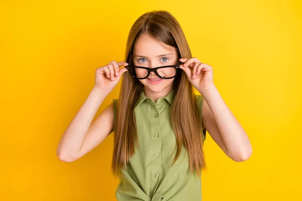 Фотопортрет школьница в зеленой рубашке снимает очки улыбаясь изолированные ярко-желтый цвет фона — стоковое фото