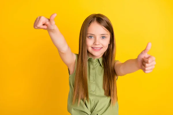 Bild av cool blond liten flicka visa tummen upp bära khaki blus isolerad på gul färg bakgrund — Stockfoto