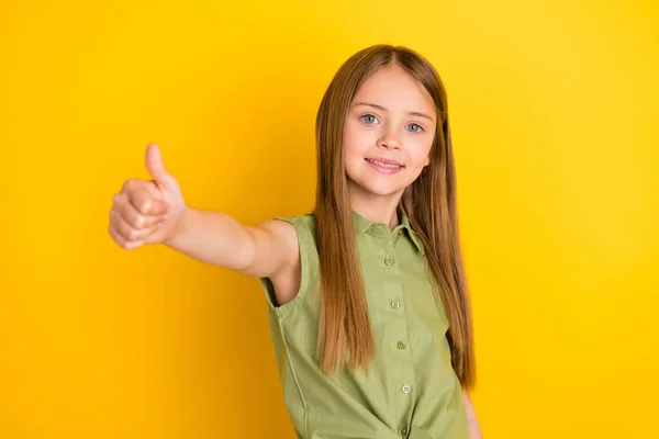 Foto de optimista rubia niña pulgar hacia arriba usar blusa caqui aislado sobre fondo de color amarillo —  Fotos de Stock