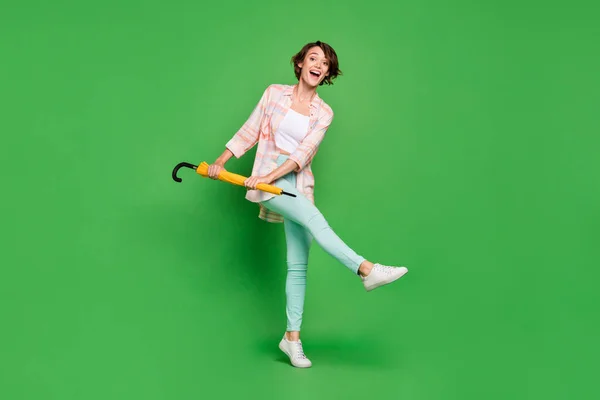 Фотографія повного розміру позитивної веселої щасливої жінки насолоджується прогнозом погоди парасольки ізольовано на фоні зеленого кольору — стокове фото