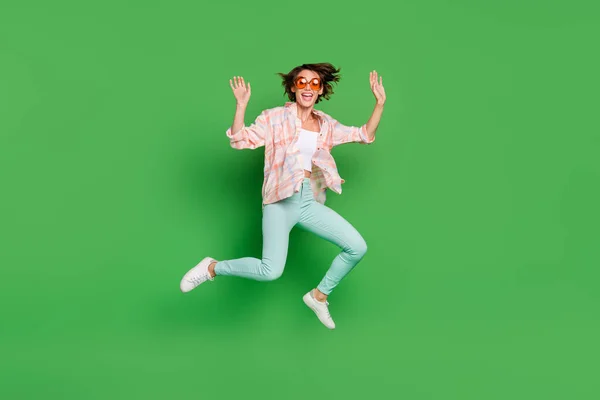 Foto de comprimento total de alegre mulher feliz positiva saltar para cima desgaste verão fresco vidro solar isolado no fundo de cor verde — Fotografia de Stock