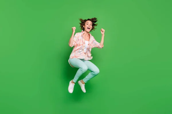 Foto de cuerpo completo de alegre sorprendida joven sorprendida saltar a la venta ganador aislado en el fondo de color verde — Foto de Stock