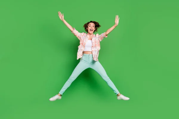 Foto de cuerpo completo de alegre positiva feliz mujer joven saltar estrella forma venta sueño aislado sobre fondo de color verde —  Fotos de Stock