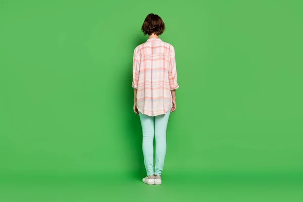 Pełna długość tylna strona tylna kręgosłup widok zdjęcie młodej kobiety nosić casual ubrania koszulka krata izolowane na zielonym tle kolor — Zdjęcie stockowe