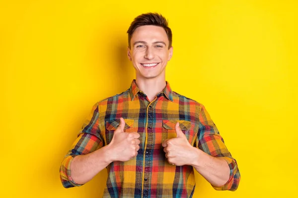魅力的な陽気な男の肖像画表示ダブル親指広告絶縁上の明るい黄色の色の背景 — ストック写真