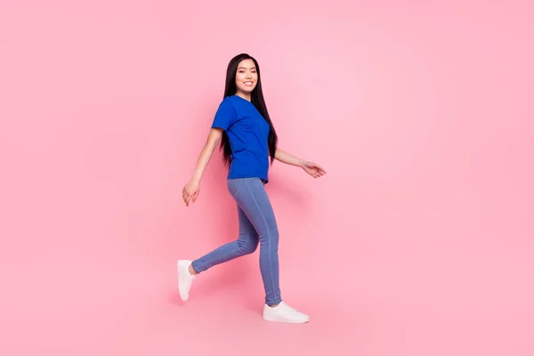 Foto de larga duración de la feliz mujer joven positiva caminar espacio vacío usar ropa casual aislado sobre fondo de color rosa pastel —  Fotos de Stock