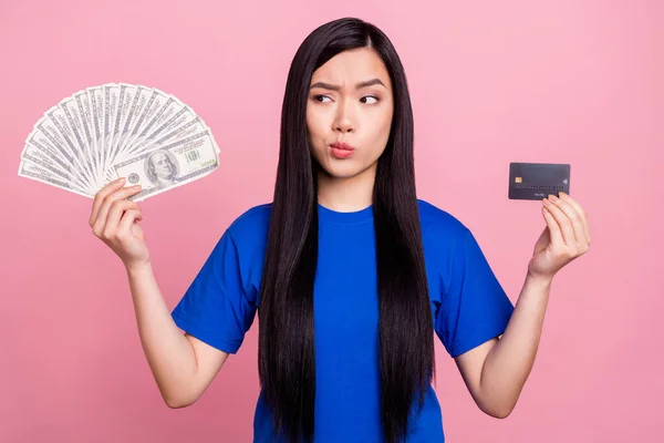 Photo de jeune femme aux cheveux bruns malheureux regarder carte de crédit prêt d'argent isolé sur fond de couleur rose — Photo